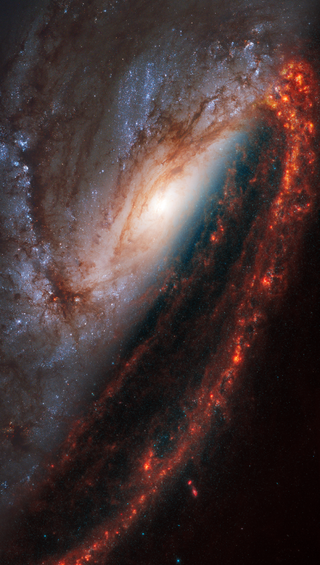 Face-on spiral galaxy, NGC 3627, is split diagonally in this image: The James Webb Space Telescope’s observations appear on bottom right, and the Hubble Space Telescope’s at top left.