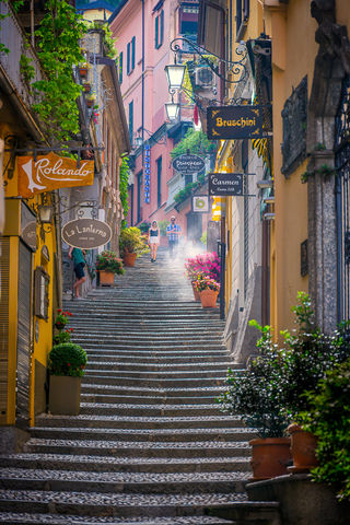 A couple walking down a misty street in Bellagio, Lake Como, Italy