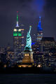 Night view of the Statue of Liberty with the Empire State Building lit up in green, white and light blue in honor of the Business of Women's Sports Summit in New York City-2023-DRFlickr.jpg